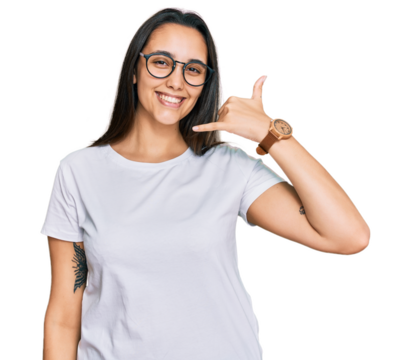 Young hispanic woman wearing casual white t shirt smiling doing phone gesture with hand and fingers like talking on the telephone. communicating concepts.