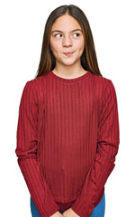 Beautiful brunette little girl wearing casual sweater smiling looking to the side and staring away...