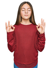Beautiful brunette little girl wearing casual sweater relax and smiling with eyes closed doing meditation gesture with fingers. yoga concept.