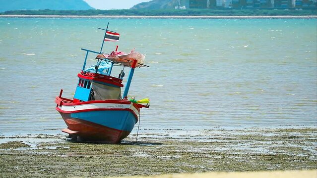 Fishing boat was anchored at a standstill during low tide during the daytime