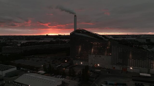Aerial view of the Amager Bakke, Copenhill Waste-to-Energy Power Plant with green ski slopes with slides and kickers at sunset. Green eco energy plant.