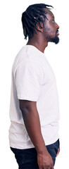 Fototapeta premium Young african american man with braids wearing casual white tshirt looking to side, relax profile pose with natural face and confident smile.