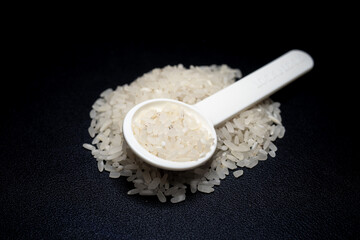 Pile of rice in a spoon with black background