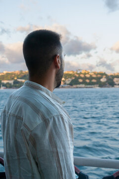 Unrecognizable young man looking at the scenery from a cruise ship on a Bosphorus tour in Istanbul, Turkey.