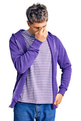 Young handsome man wearing casual purple sweatshirt tired rubbing nose and eyes feeling fatigue and headache. stress and frustration concept.