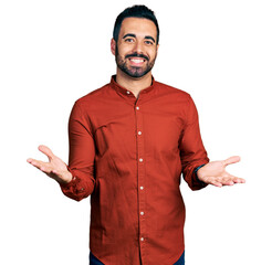 Young hispanic man with beard wearing casual shirt smiling cheerful with open arms as friendly welcome, positive and confident greetings