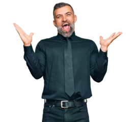 Middle age handsome man wearing business clothes celebrating victory with happy smile and winner expression with raised hands