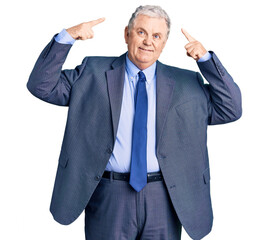 Senior grey-haired man wearing business jacket smiling pointing to head with both hands finger, great idea or thought, good memory