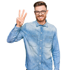 Young redhead man wearing casual denim shirt showing and pointing up with fingers number three while smiling confident and happy.
