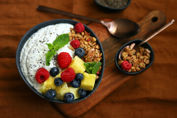 Healthy breakfast bowl with chia yogurt, crunches and fruits.