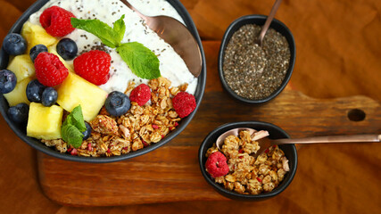 Healthy breakfast bowl with chia yogurt, crunches and fruits.