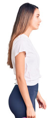 Young beautiful girl wearing casual t shirt looking to side, relax profile pose with natural face with confident smile.