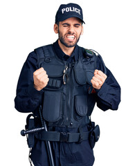 Young handsome man with beard wearing police uniform very happy and excited doing winner gesture with arms raised, smiling and screaming for success. celebration concept.