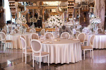 Tables setting at a luxury wedding. Table for guests. Dishes and drinks. Wedding table preparation.
