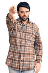 Young hispanic man wearing casual clothes looking unhappy and angry showing rejection and negative with thumbs down gesture. bad expression.