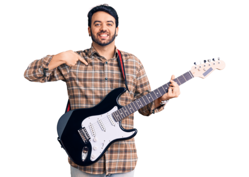 Young hispanic man playing electric guitar pointing finger to one self smiling happy and proud