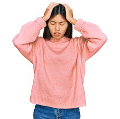 Beautiful young asian woman wearing casual winter sweater suffering from headache desperate and stressed because pain and migraine. hands on head.