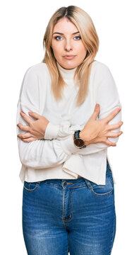 Young caucasian woman wearing casual winter sweater shaking and freezing for winter cold with sad and shock expression on face