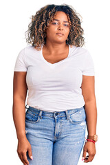 Young african american plus size woman wearing casual clothes relaxed with serious expression on face. simple and natural looking at the camera.