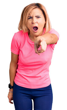 Young blonde woman wearing sportswear pointing displeased and frustrated to the camera, angry and furious with you