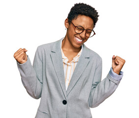 Young african american woman wearing business clothes very happy and excited doing winner gesture...