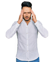 Young arab man wearing casual clothes with hand on head for pain in head because stress. suffering migraine.