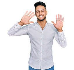Young arab man wearing casual clothes showing and pointing up with fingers number ten while smiling confident and happy.