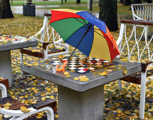 Rainy autumn day in the park on the chess court.