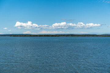 Sea stretching to Stradbroke Island in the distance, with clouds sitting about the horizon, at Redland Bay, Queensland, Australia 