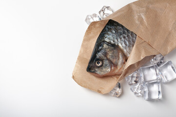 Close-up top view of delicious freshwater fish in paper. Crucian carp.