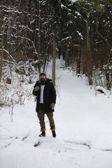 Bearded man in the winter woods. Attractive happy young man with beard walk in the park.