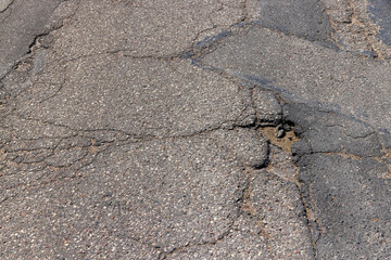 An old paved road with a lot of holes and damage
