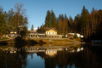 Blausee , beautiful turquoise lake and Blausee Hotel and Spa in  Kandergrund during autumn , winter morning : Blausee , Switzerland : December 4 , 2019