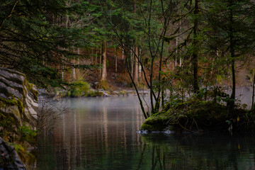 Blausee , beautiful turquoise nature lake in Bernese Oberland, Kandergrund during autumn , winter morning : Blausee , Switzerland : December 4 , 2019