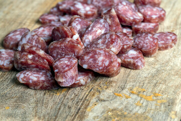 sliced thin sausage with bacon on a wooden dish