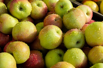 green apples with red sides covered with water droplets