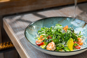 salad with shrimp, avocado, fresh vegetables and herbs, served with white wine