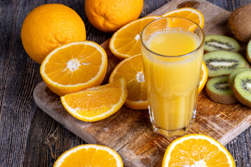 uncut orange on a wooden chopping board