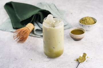 Step by step matcha latte: tall boba tea glass with ice, matcha green tea, milk