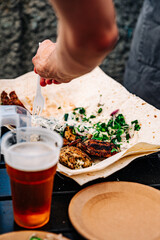 man hand holding plastic fork with meat and sause outdoor