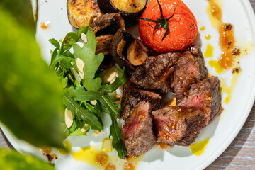 barbecue with grilled vegetables with fresh herbs on a white plate