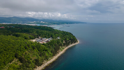 Beautiful and long sea coast. Colorful landscape. Forests grow on mountains. Clouds in the blue sky. Beautiful nature.