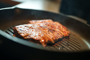 Beef entrecote is fried in a pan.