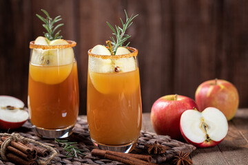 Apple cider cocktail with sliced apples and rosemary
