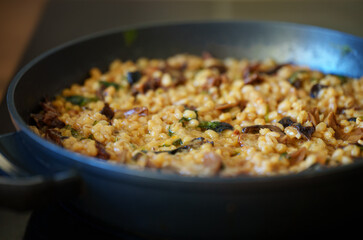 Golden orzotto with pearl barley preparing in pan.