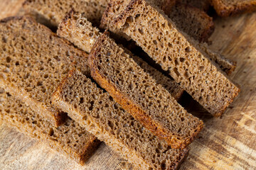 Sliced piece of black rye bread on a board
