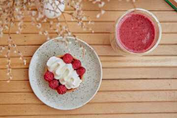 Aesthetic healthy autumn lunch - pink strawberry smoothie and french tart on the wooden table