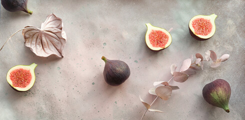 Panoramic banner Autumntime background with fresh halved fig fruits. Dry eucalyptus and cala lily...