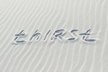 thirst written with a finger on the white sand, word on the sand