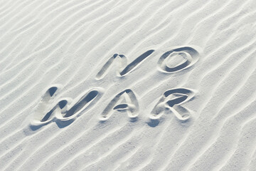 no war written with finger on white sand, 